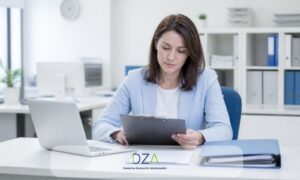 Personalverantwortliche prüft eine Vorsorgebescheinigung am Schreibtisch neben Laptop und Aktenordner