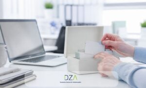 Hände ordnen Karteikarten in einen Karteikasten neben einem Laptop – Symbolbild für die Vorsorgekartei des Arbeitgebers